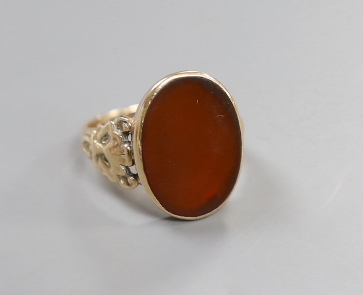 A 1970's Victorian style 9ct gold and carnelian set oval signet ring, with carved shoulders, size T, gross weight 6 grams.